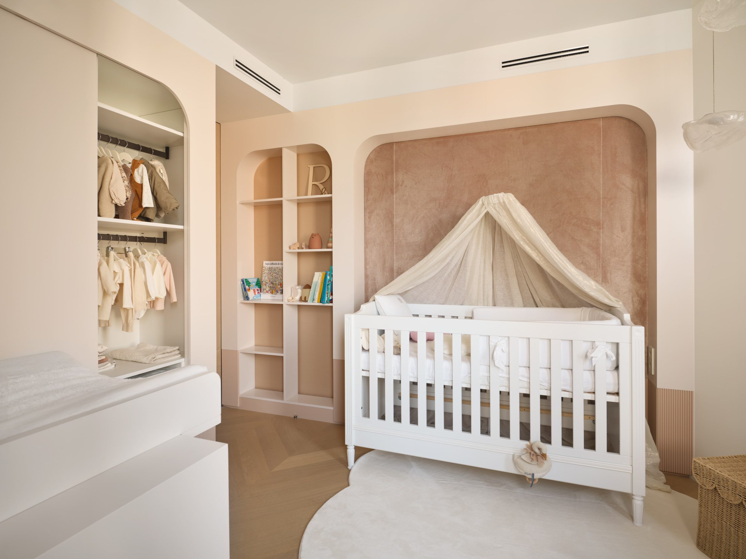 Chambre d'enfant au style vintage avec les meubles sur mesure aux coins arrondis, dans les tons de beige et rosé pour une petite fille