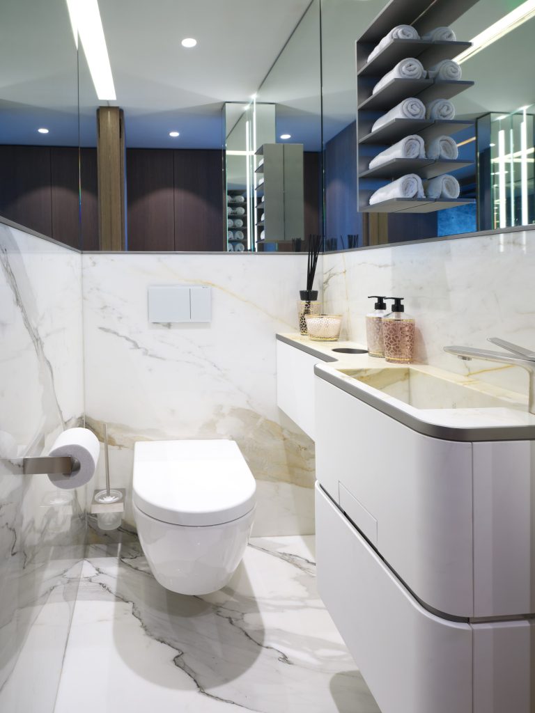 WC (toilettes) avec mobilier en Corian blanc et miroirs sur mesure