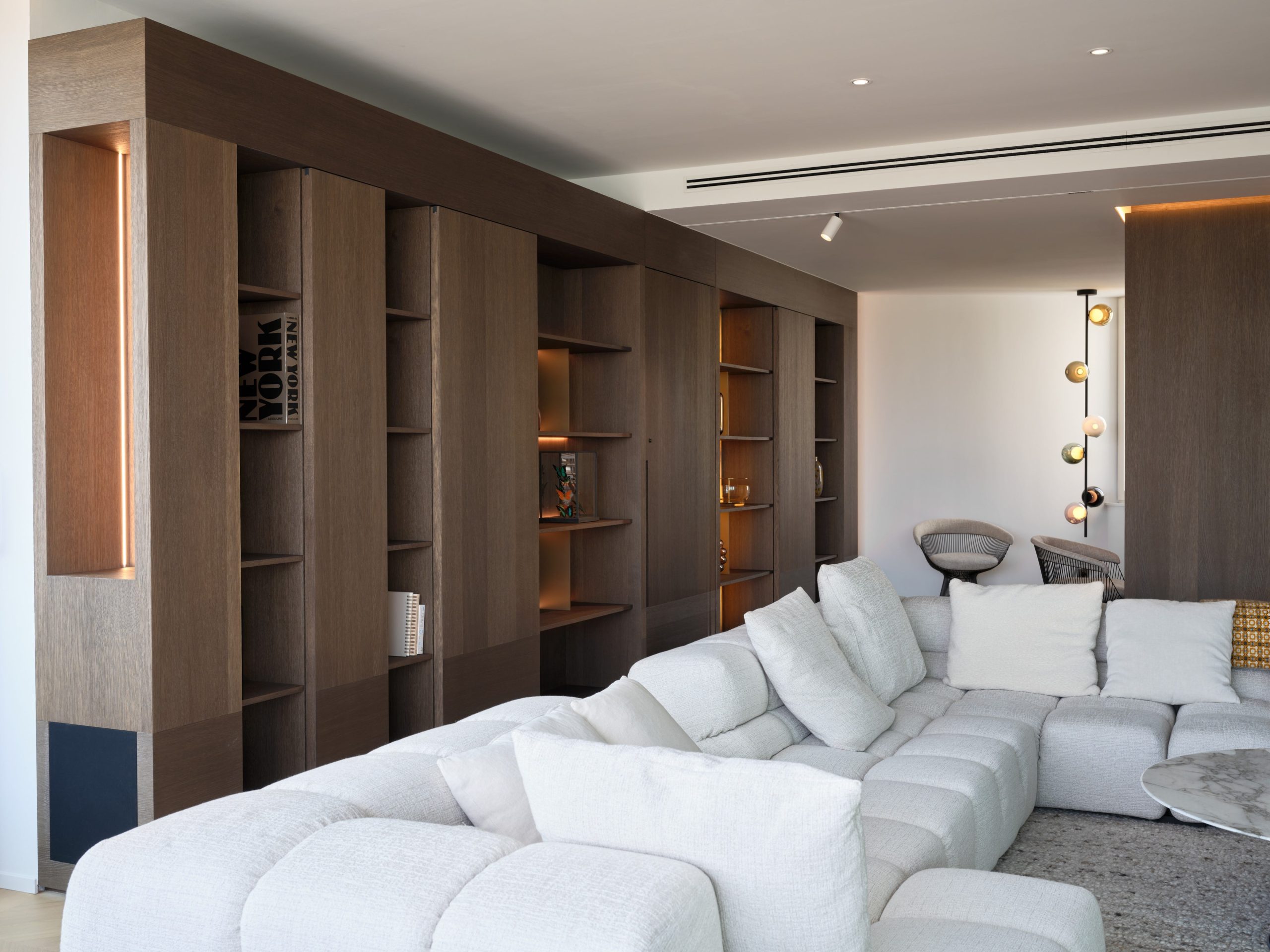 Mobilier sur mesure avec portes coulissantes en chêne brossé, teinté et vernis, au cœur du salon d'un penthouse à Liège