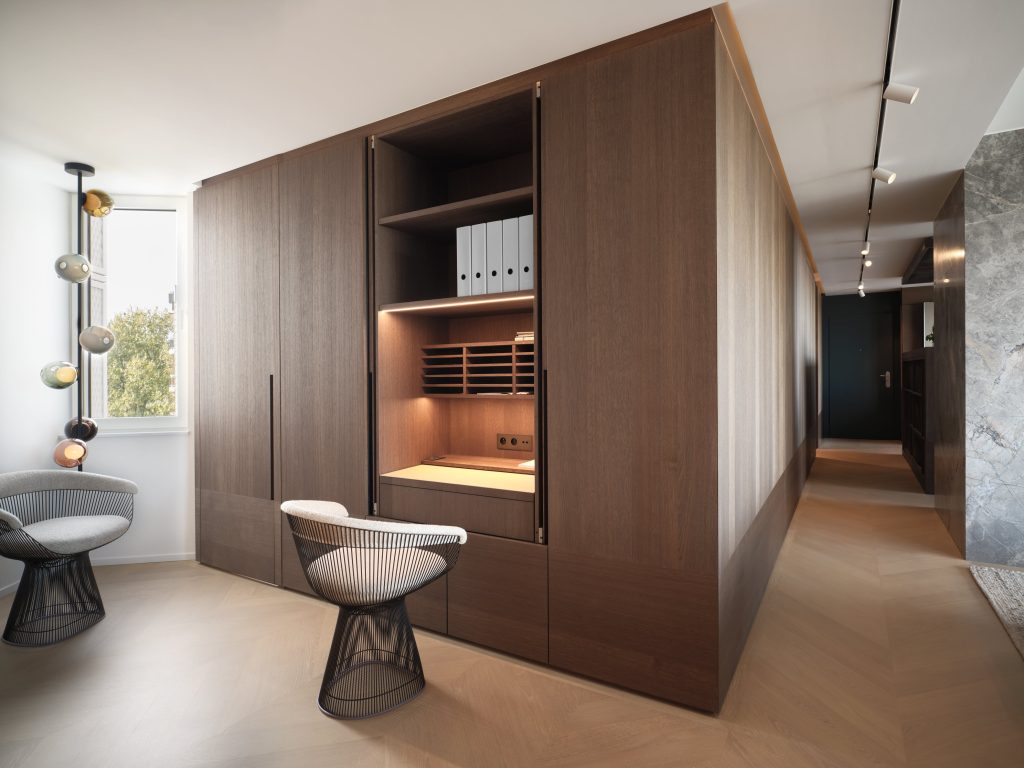 Mobilier sur mesure pour réaliser un espace bureau en chêne brossé, teinté et vernis, au cœur du salon d'un penthouse à Liège avec porte dérobée pour donner l'accès au dressing