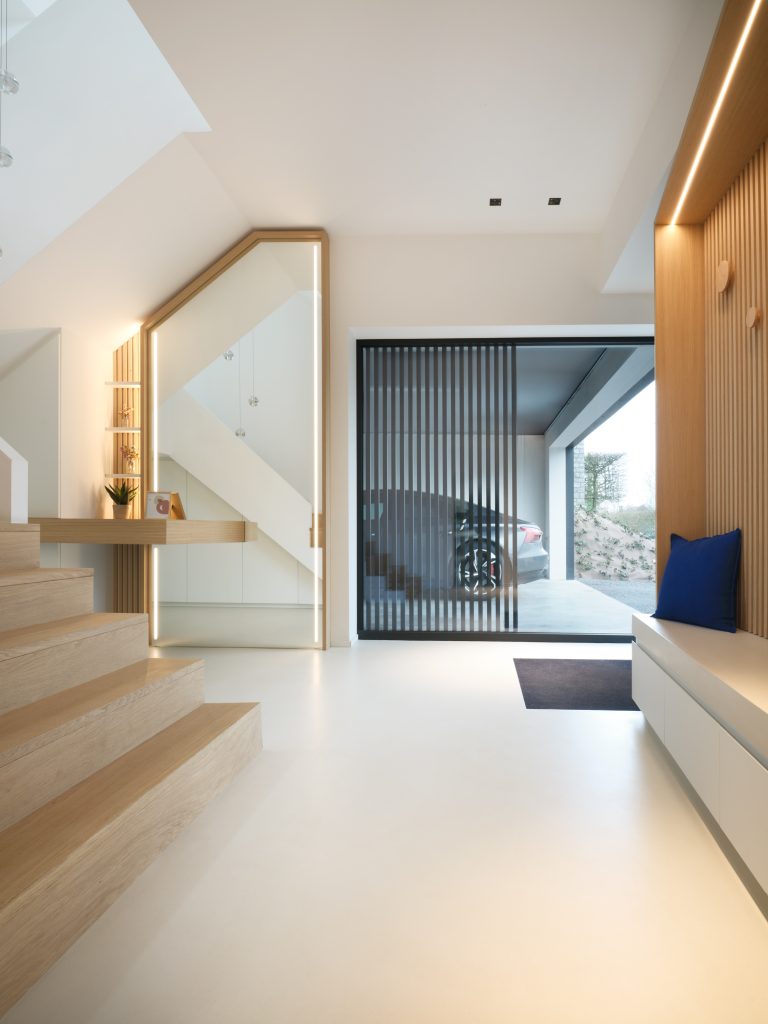 hall d'entrée contemporain, en blanc et chêne clair avec un grand miroir et des placards sur mesure, sous l'escalier